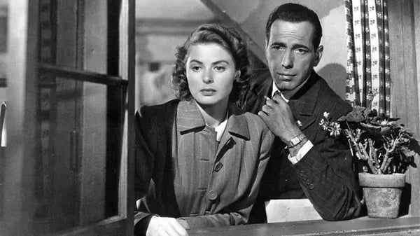 Black and white scene from Casablanca of a man behind a woman staring longingly out a window.