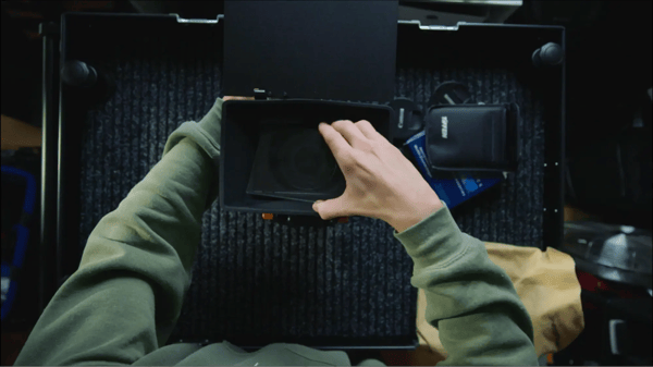 Demonstration of someone inserting a diffusion filter into a camera's matte box.