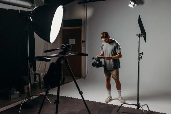 A filmmaker illuminated by a soft box to the left, and a hard light behind him