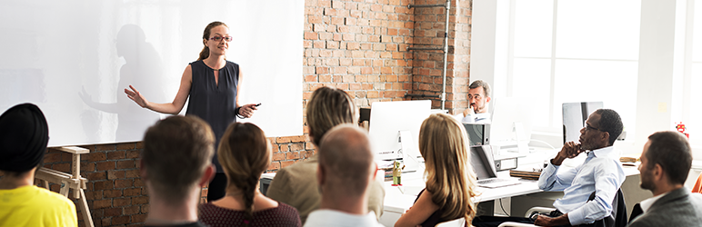 Woman presenting to team in trendy office workspace. 