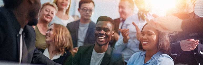 Engaged employees sitting in a meeting shaking hands with CEO and smiling