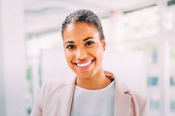 Business woman smiling at camera in a bright office space