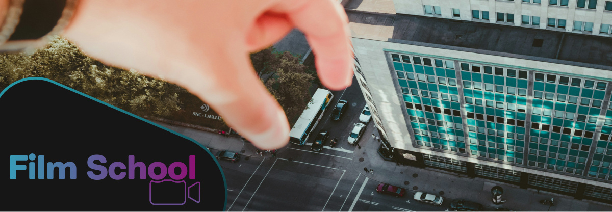 Forced perspective shot of giant hand reaching into city. WeVideo Film School logo in bottom left corner. 