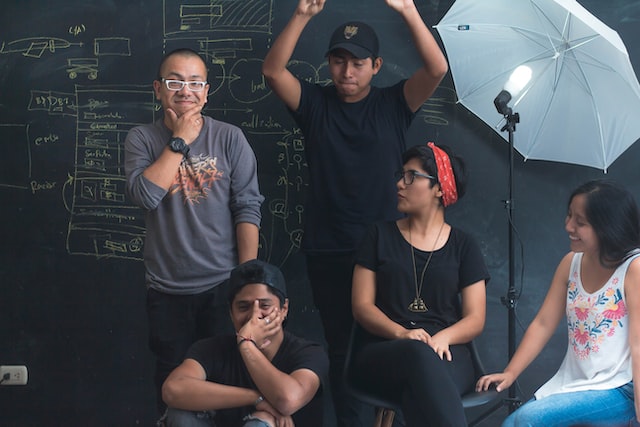 Group of people planning recording session under camera lights