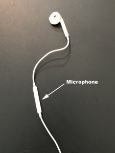 Apple wired headphone, with arrow and text pointing out the microphone part. 