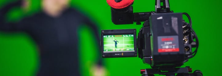 Person recording in front of green screen.