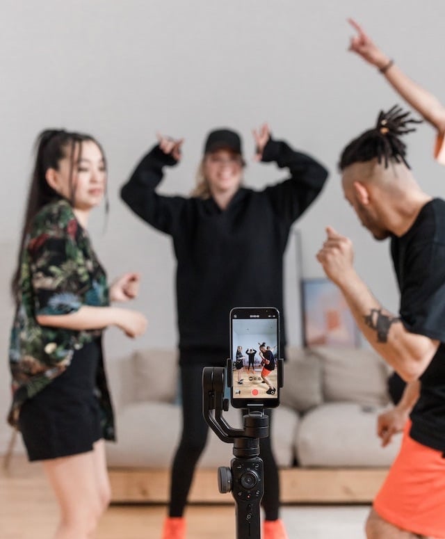People dancing in front of camera on phone.