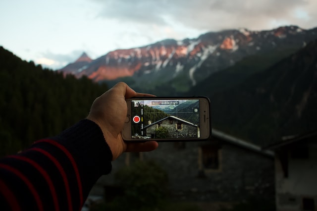 Person taking video of mountains to create YouTube video