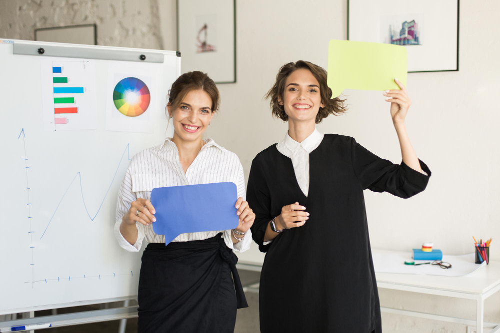 Two employees standing in front of a whiteboard showing impact of engaged employees