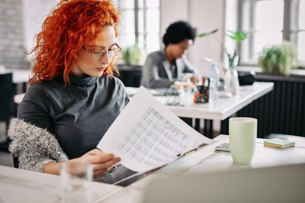 Two women filling out an employee engagement survey in a modern bright office