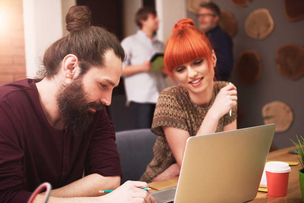 Two people sitting in front of laptop making corporate videos.jpg