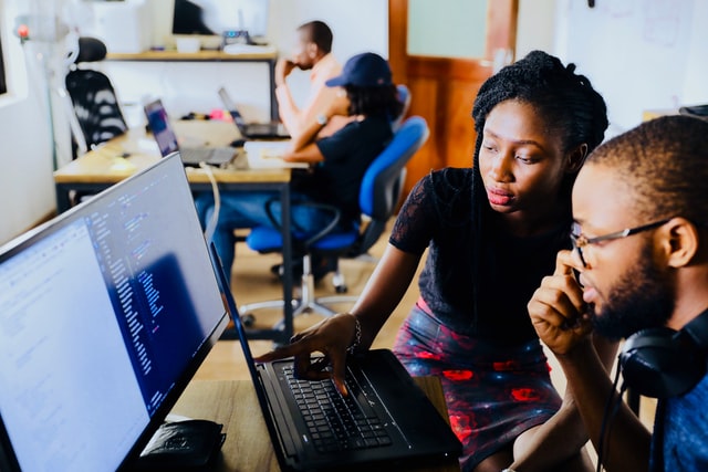 Two people looking at the computer together.