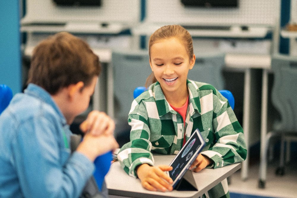 Young student showing a tablet to another student