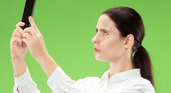 Person looking at a phone in front of a green screen