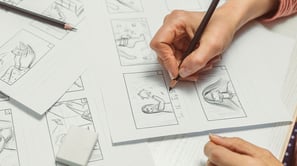 Artist drawing a storyboard on a piece of paper. 