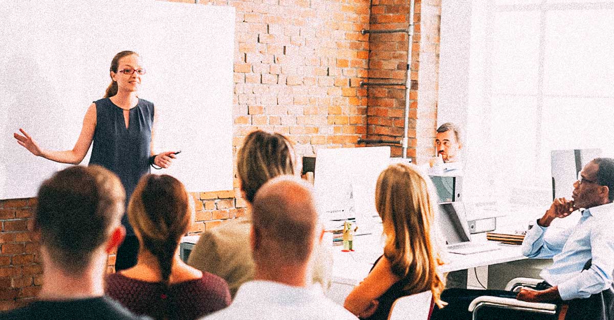 Woman presenting to team in trendy office workspace. 