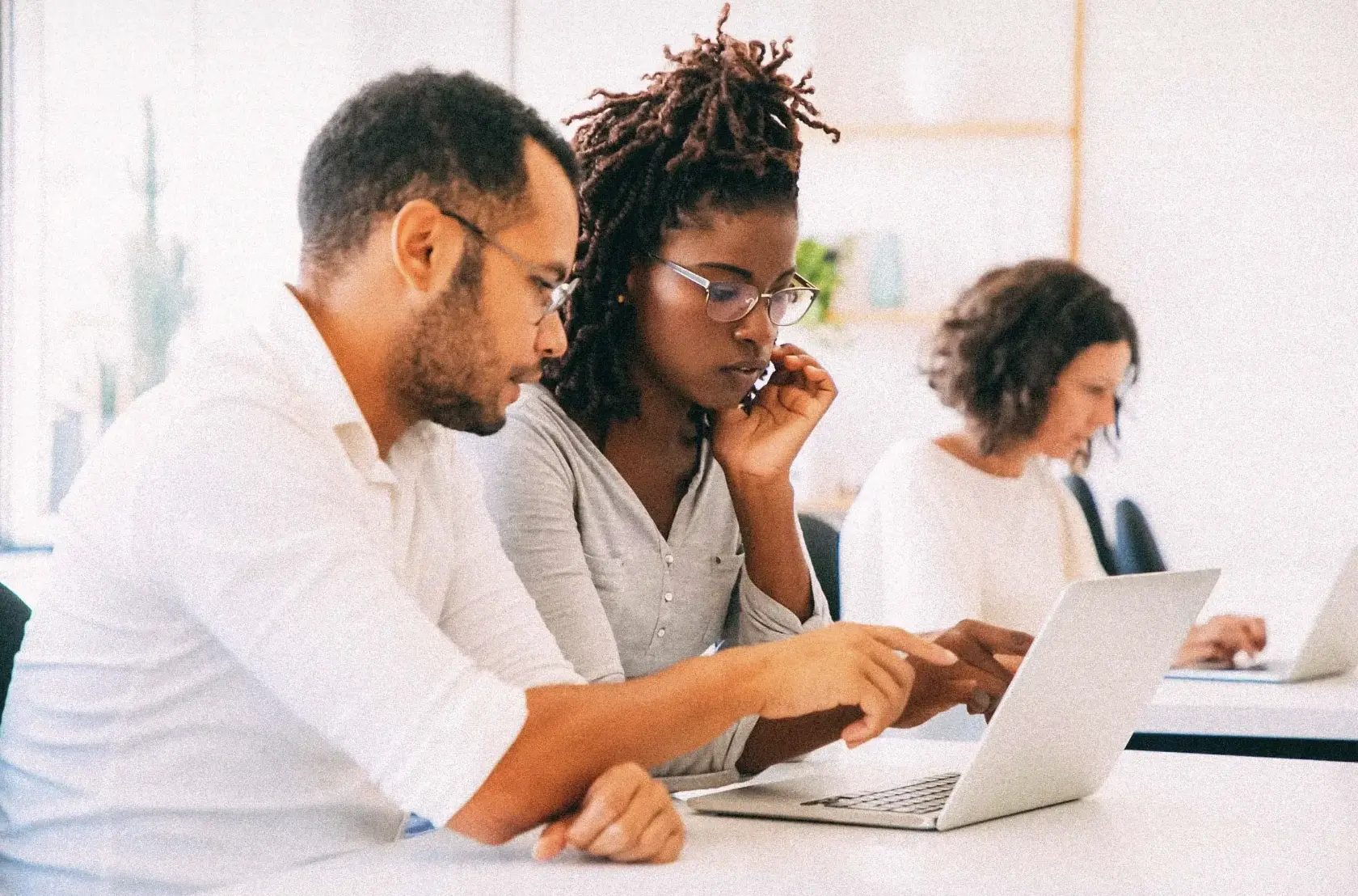 Male and female classmates sitting next to each other and collaborating at a computer