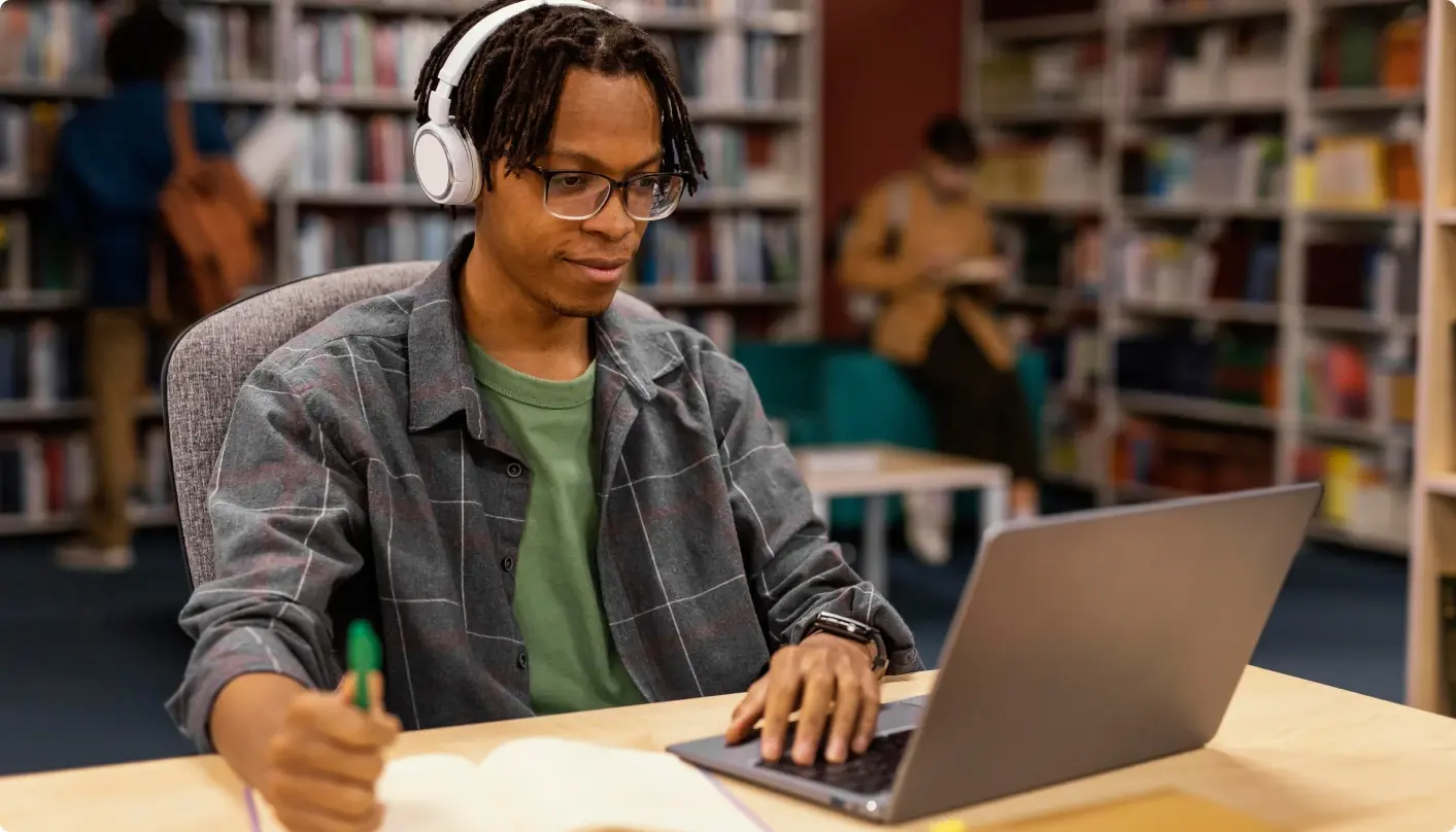 Student sitting at a laptop in the library participating in career coaching.