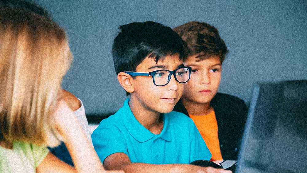 Three elementary students making videos on Chromebook laptop
