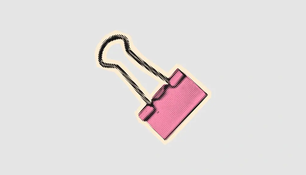Pink paperclip with light yellow highlight against gray background