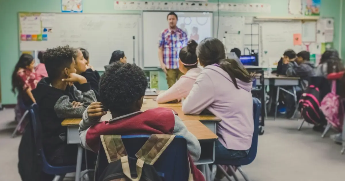 Classroom of students focusing on teacher.