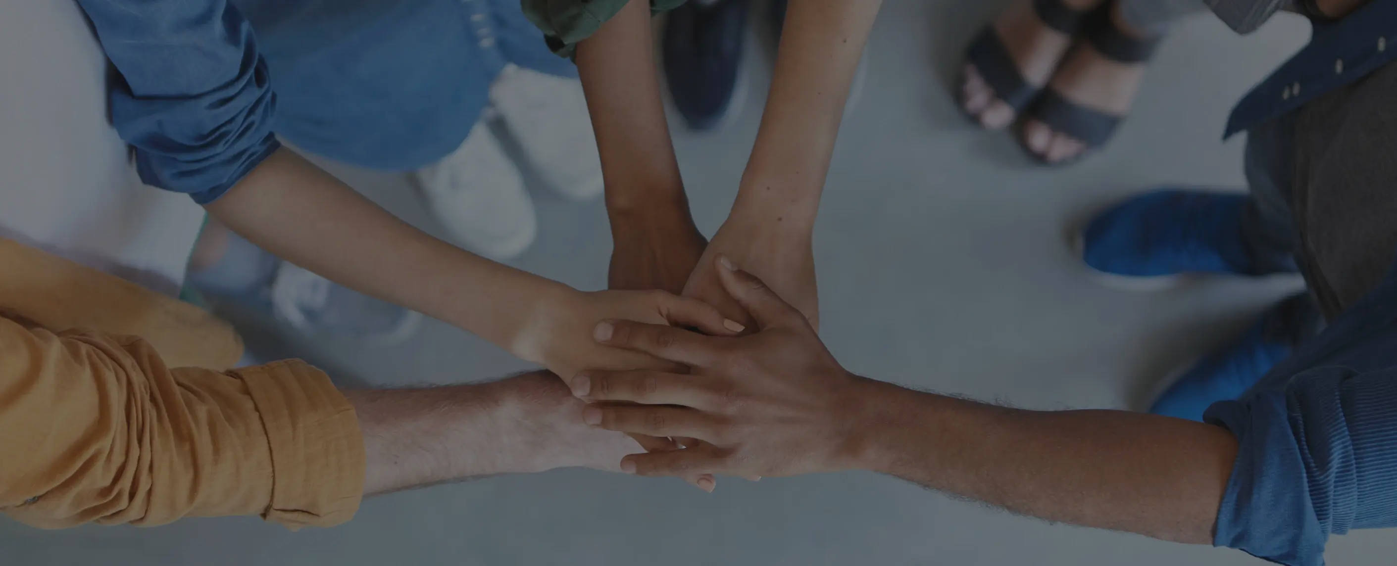 Group of 4 people with hands together.