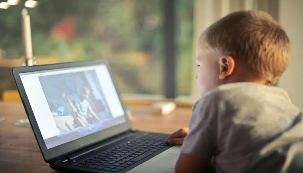 Blond male learner creating a video on his computer