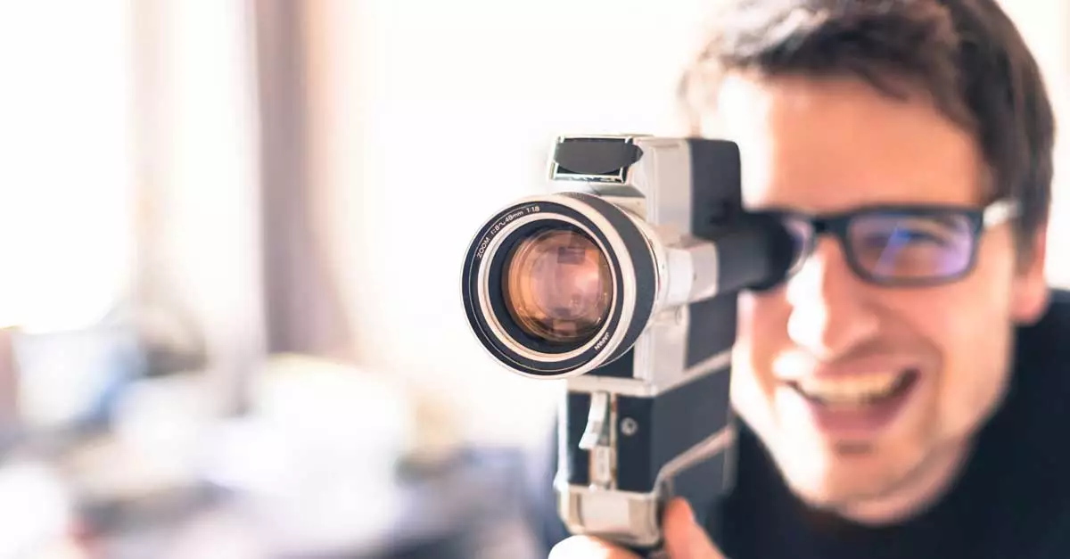 Close-up shot of man holding vintage camcorder zooming in