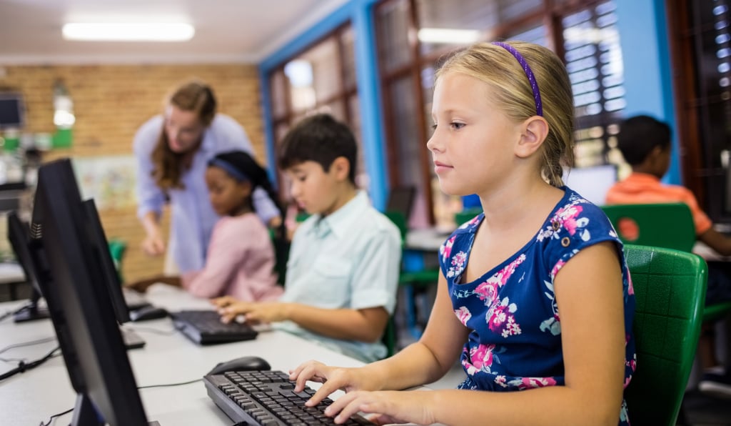 Young children working on computers in the classroom. 