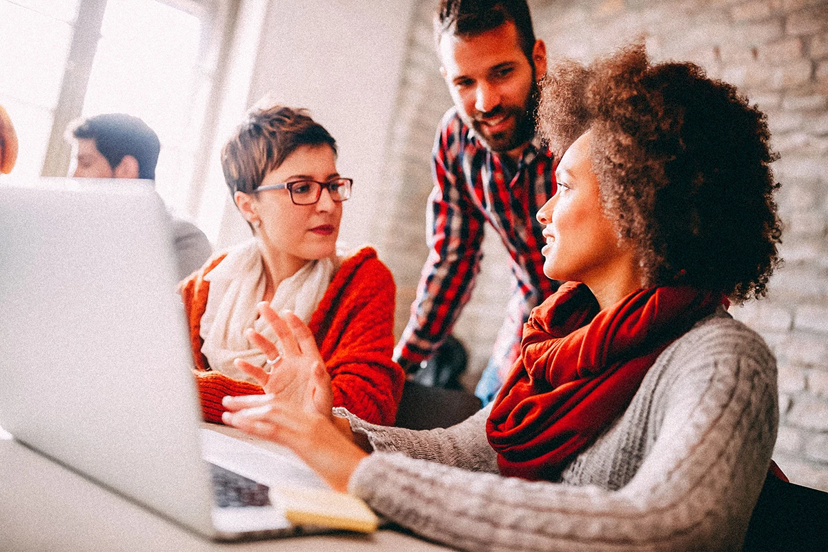 Team of professionals working on laptop in business office. 
