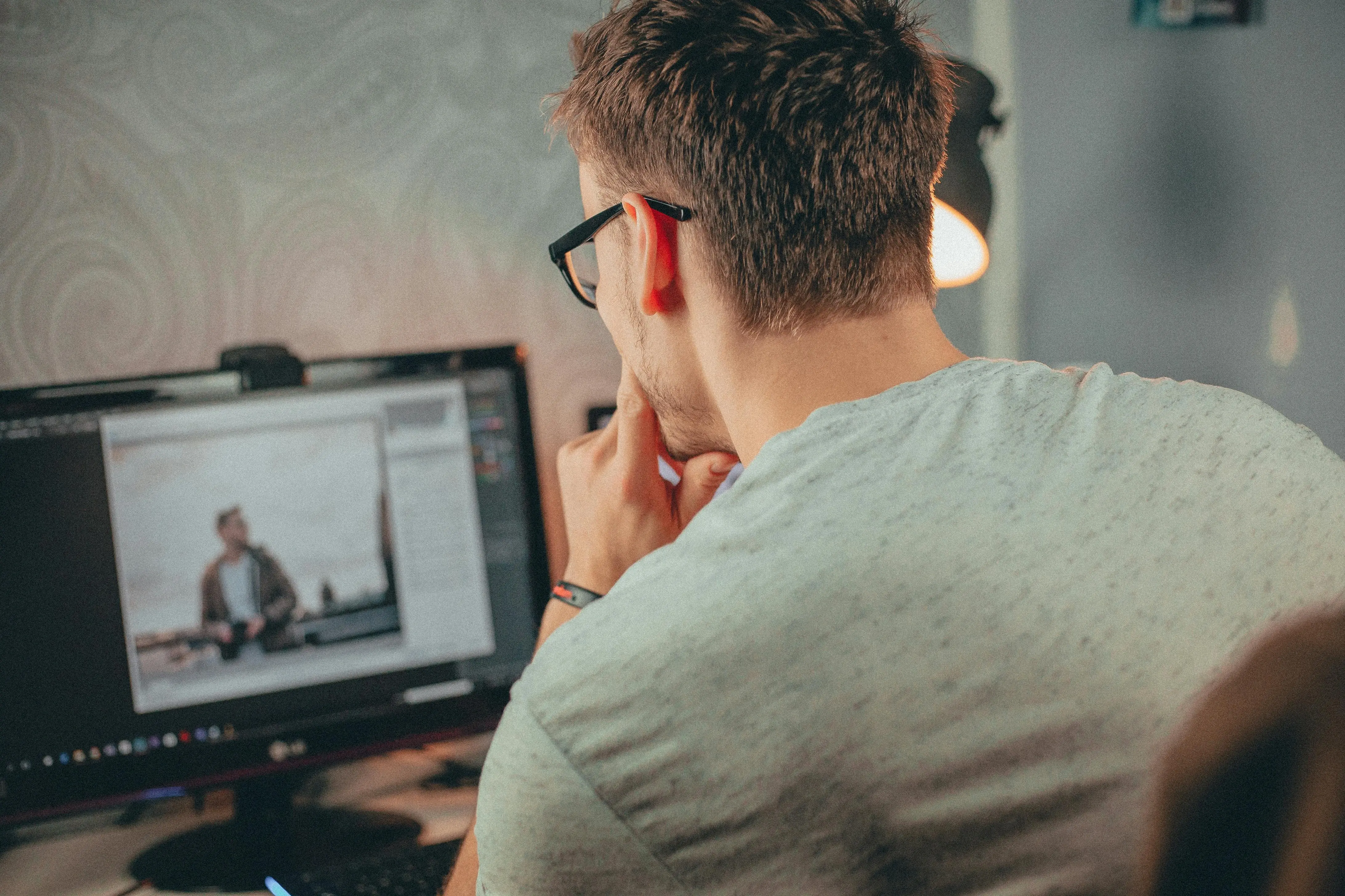 Man sitting at computer working on a video editor