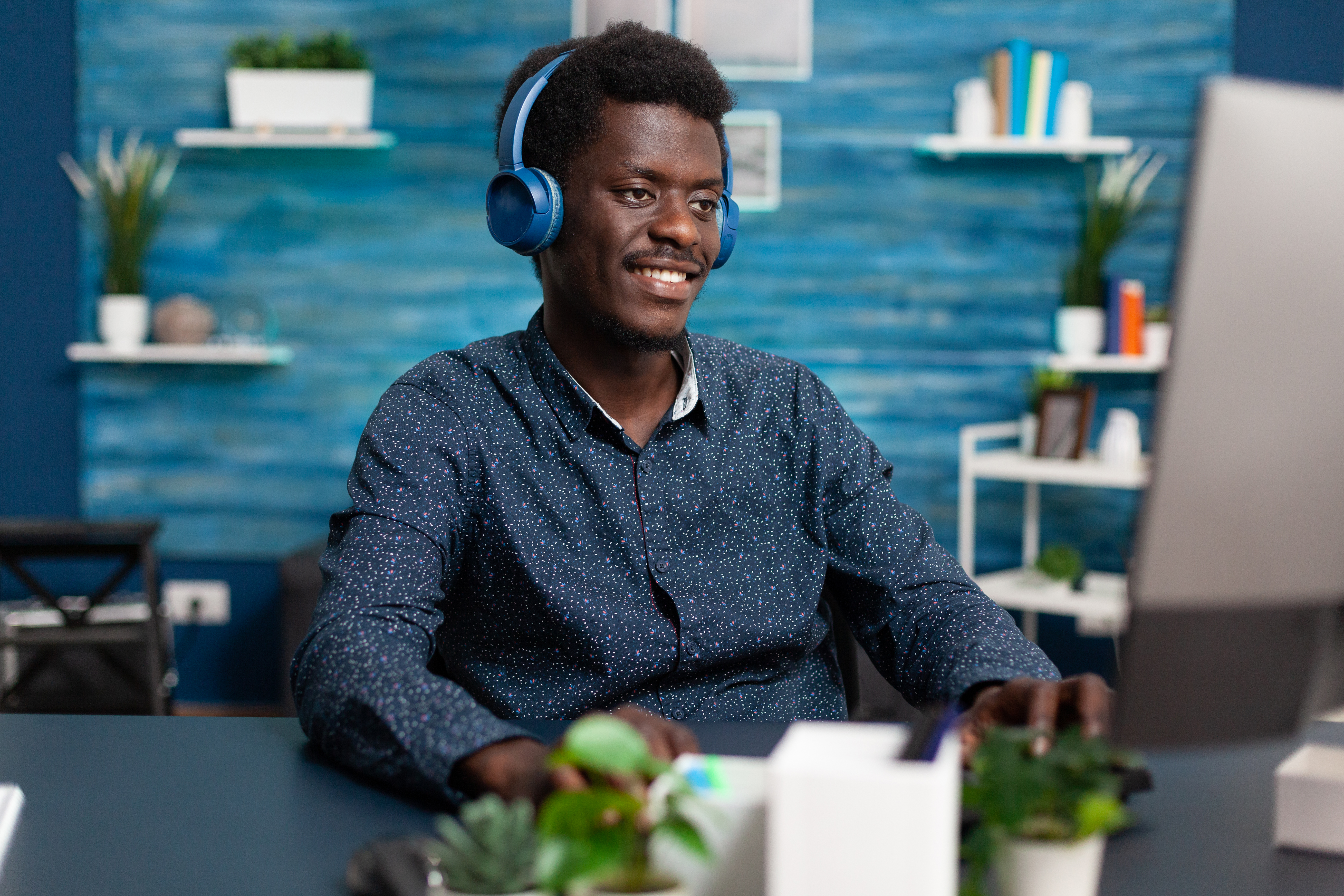 Man in headphones smiling while adding music to a video