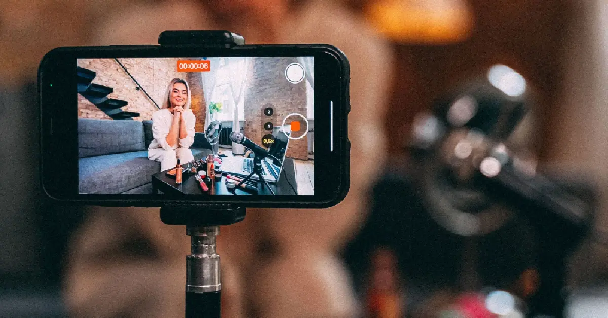 Smartphone showing a YouTube video recording with woman on a couch as the video subject