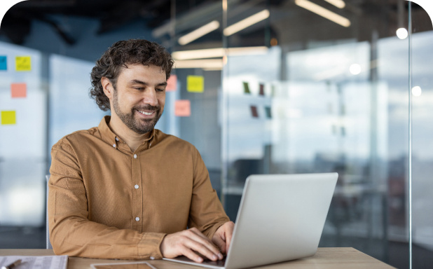 Employee working on laptop in modern office space.