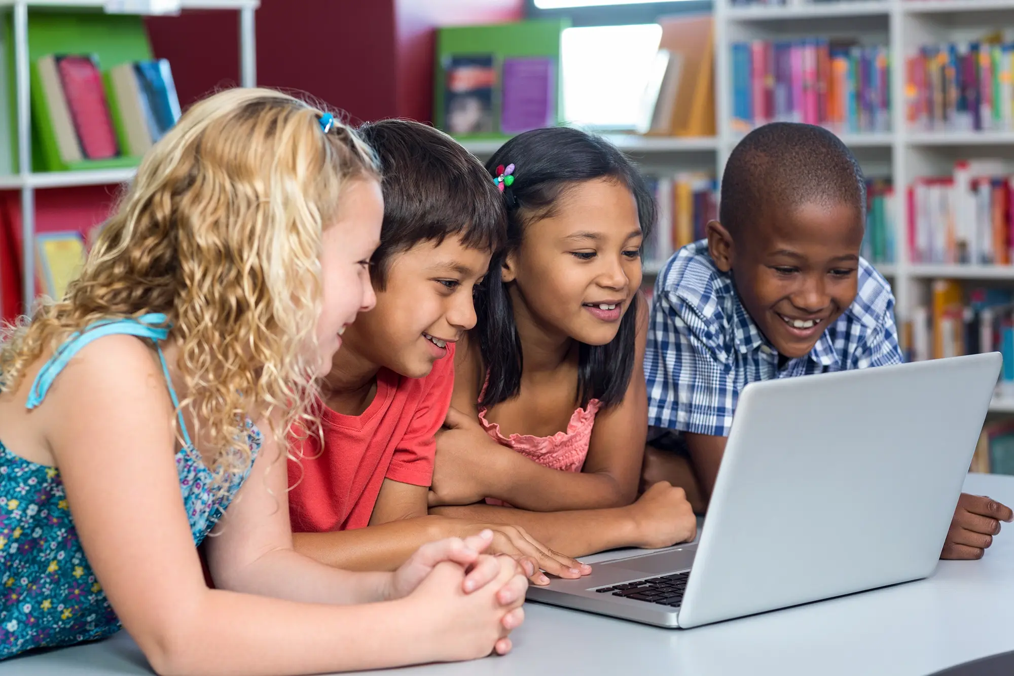 happy-multi-ethnic-classmates-looking-laptop