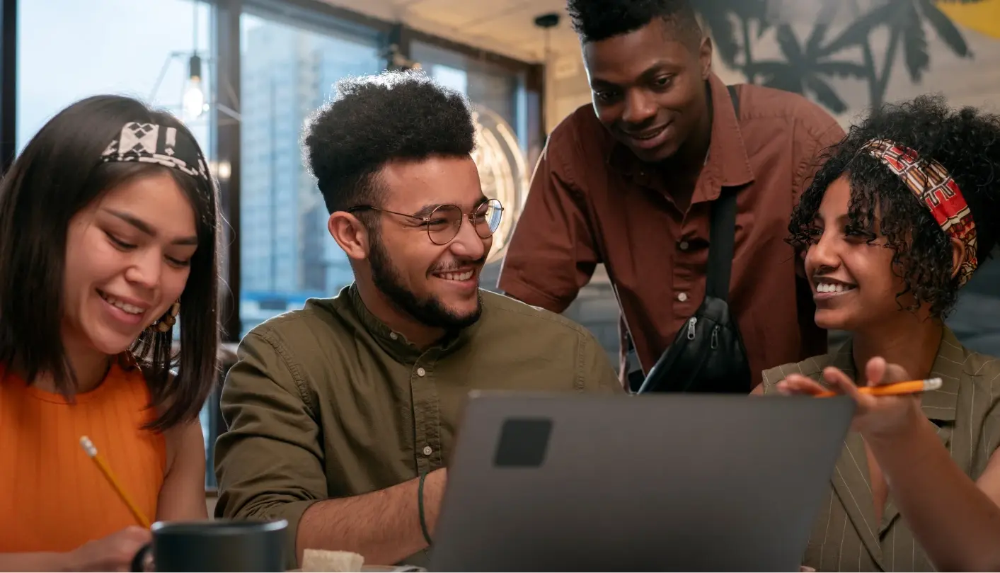 A group of friends hanging out around a laptop.