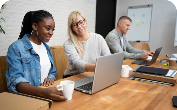 Three employees working together on laptops.