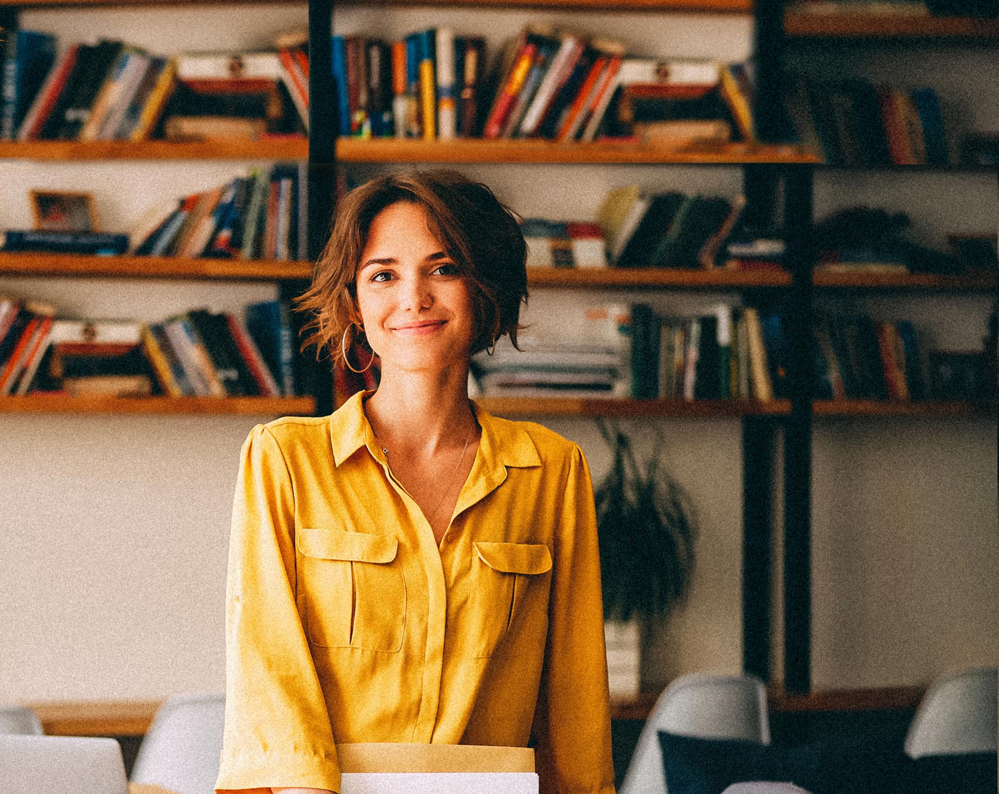 Smiling business woman in her office wearing a yellow shirt