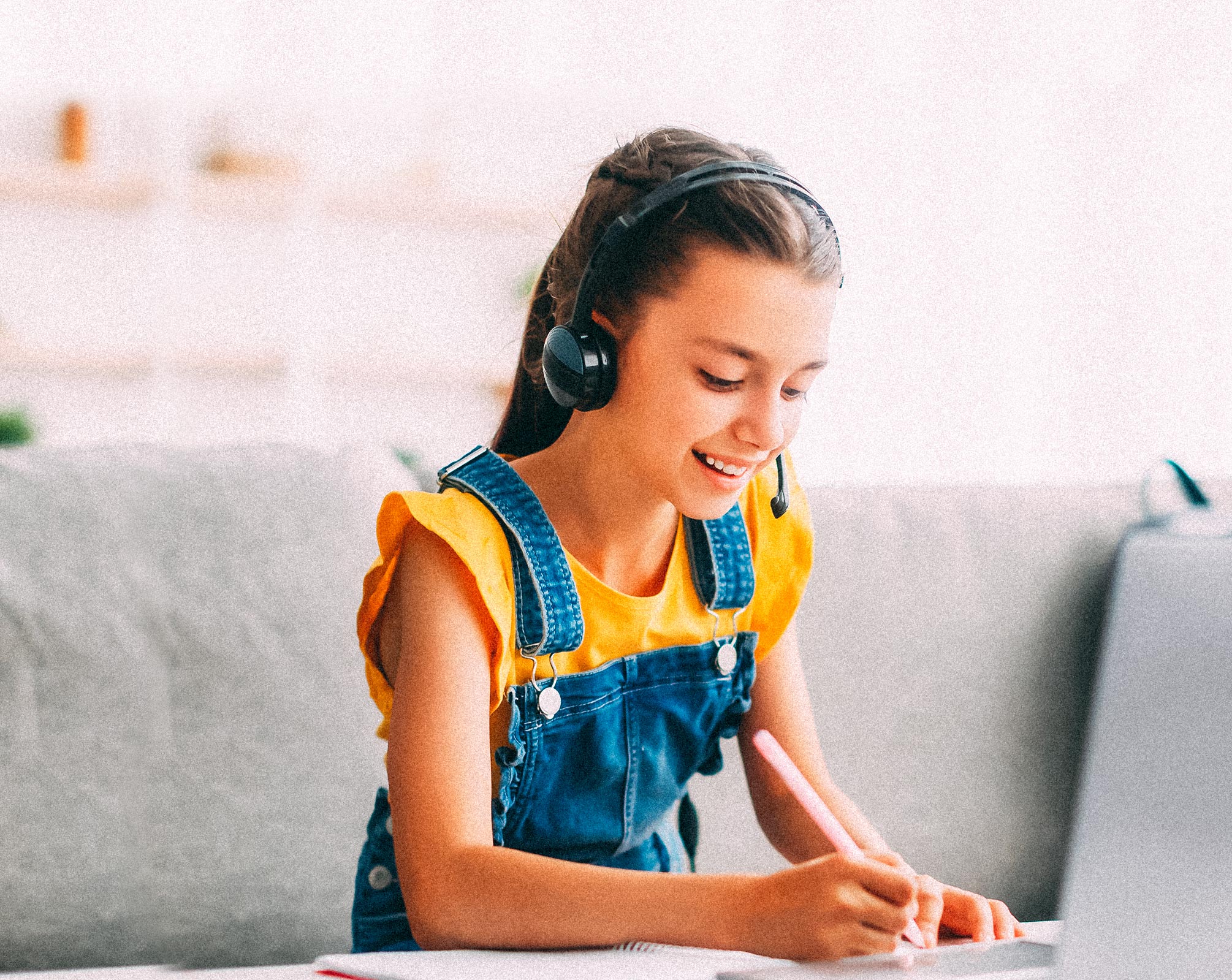 Elementary-aged girl with headset watching a video for homework