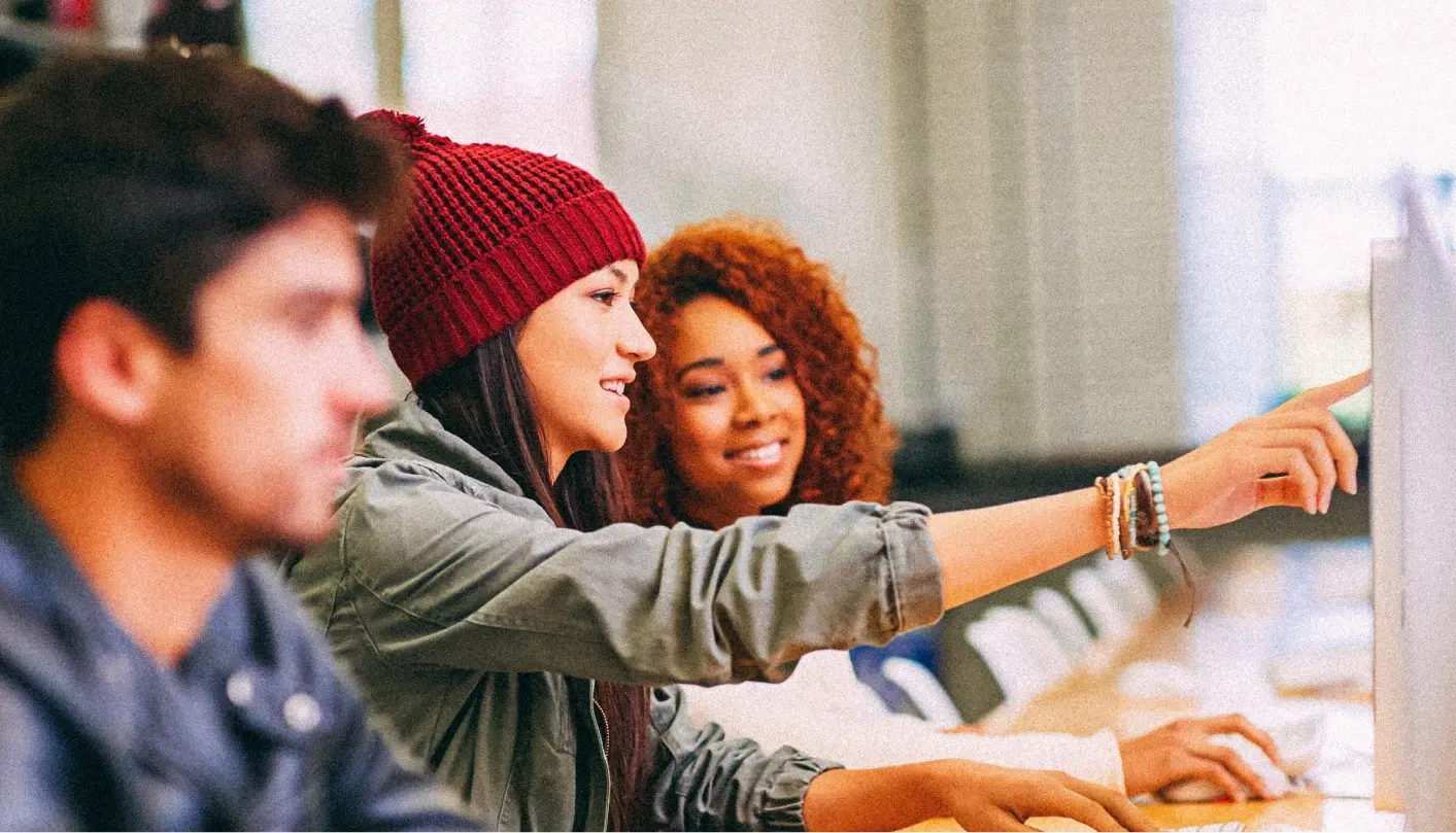 Two women talking about what's on the computer.
