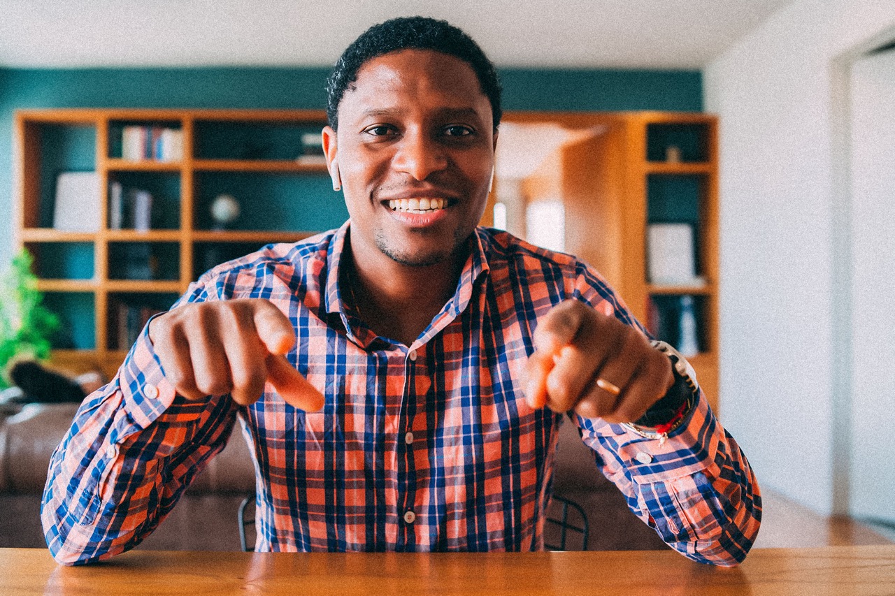 Man pointing at camera with both hands in friendly gesture
